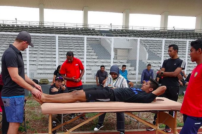 Bringing podiatrist checking Indonesian Athletics foot conditions